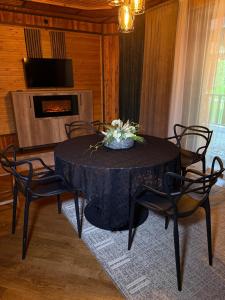 a dining room with a table with chairs and a fireplace at Садиба Володар in Kosiv +8 photos
