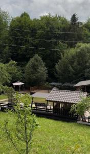 a group of picnic tables in a park with trees at Садиба Володар in Kosiv