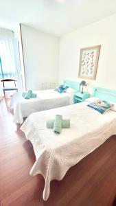 a room with three beds with towels on them at Ocean Suances in Suances