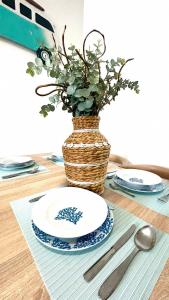a table with a plate and a vase with a plant at Ocean Suances in Suances