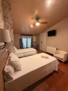 a bedroom with two beds and a ceiling fan at Hotel Río Escabas in Cañamares +60 photos