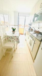 a kitchen with a table and a chair in a room at Ocean Suances in Suances +33 photos