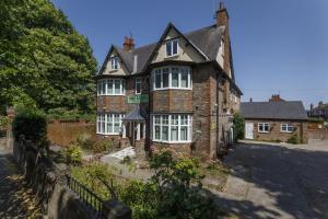 an old brick house with white windows on a street at The Limes in York