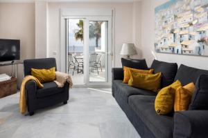 a living room with a gray couch and yellow pillows at Beachfront Apt Torrox Costa in Torrox