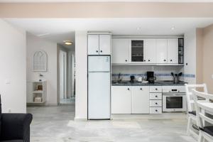 a kitchen with white cabinets and a refrigerator at Beachfront Apt Torrox Costa in Torrox