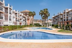 a swimming pool in front of some apartment buildings at Beachfront Apt Torrox Costa in Torrox