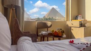 Un pat sau paturi într-o cameră la Pyramids Palace View INN
