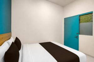 a bedroom with a bed with a blue door at Collection O near Tunjungan Plaza formerly K15 in Kedongdong +29 photos