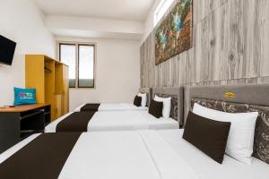 a hotel room with two beds and a tv at Collection O near Tunjungan Plaza formerly K15 in Kedongdong