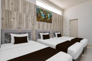 a bedroom with two beds and a painting on the wall at Collection O near Tunjungan Plaza formerly K15 in Kedongdong
