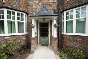a brick house with a green door and windows at The Limes in York