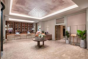 a lobby with a vase of flowers on a table at Mercure Kunming Wujiaba in Kunming