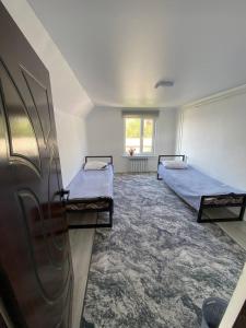 a bedroom with two beds and a window at Syrgak in Dzhergalan