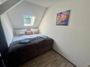 a small bedroom with a bed with a painting on the wall at 3 Zimmer Ferienwohnung Greizer Straße in Reichenbach im Vogtland