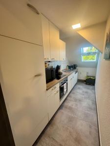 a kitchen with white cabinets and a stove top oven at 3 Zimmer Ferienwohnung Greizer Straße in Reichenbach im Vogtland