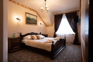 a bedroom with a bed and a chandelier at Hotel Trylogia in Zielonka