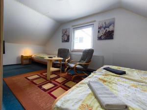 a bedroom with a bed and a table and chairs at Penzion Pomněnka in Lipova Lazne