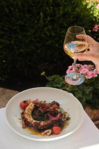 a person holding a glass of wine next to a plate of food at Hôtel Arnold in Itterswiller +106 photos