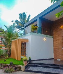 a house with a white and blue facade at KRISHNASHILa in Varkala