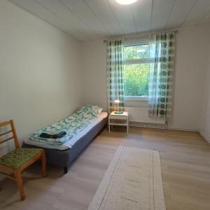 a bedroom with a bed and a chair and a window at Villa Aspen in Kokkola +8 photos