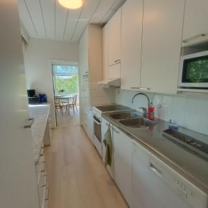 a kitchen with white cabinets and a sink at Villa Aspen in Kokkola