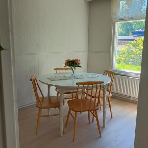 a dining room table with chairs and a vase of flowers on it at Villa Aspen in Kokkola