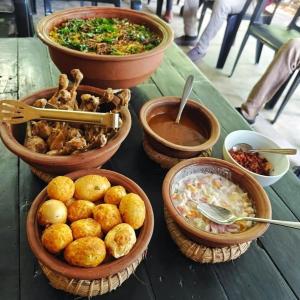 a table topped with bowls of food and bowls of soup at Sri Craft Algama in Uduwaka