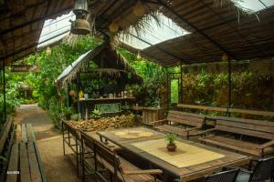 a restaurant with a wooden table and chairs and plants at Sri Craft Algama in Uduwaka