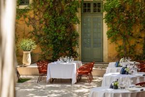 a group of tables and chairs with white tablecloths at Margaret - Hôtel Chouleur in Nîmes