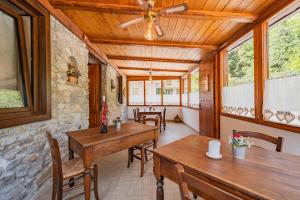 a porch with wooden tables and chairs and windows at Meublé la Ciastella in Vinadio