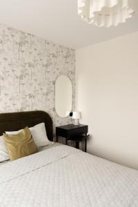 a bedroom with a bed and a wall with a mirror at AN apartment 5 in Rēzekne