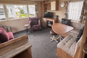 a living room with a couch and a table at Rubys Place on Lyons Winkups Towyn Sleeps 6 in Abergele