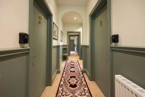 a hallway with green and white walls and a rug at The Limes in York