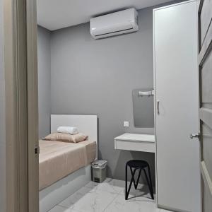 a small white room with a bed and a sink at B&B By JumStay in Sepang
