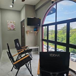 a room with two chairs and a table and a large window at B&B By JumStay in Sepang
