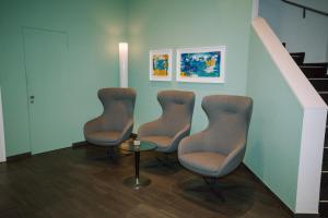 a waiting room with three chairs and a table at Hotel Zofingen in Zofingen