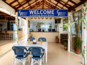 a white table with blue chairs in a restaurant at Bolabog Beach Resort in Boracay