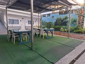 a patio with a table and chairs on a green carpet at Bolabog Beach Resort in Boracay
