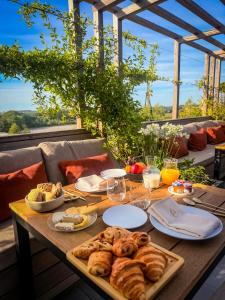 ein Tisch mit Brot und anderen Speisen in der Unterkunft Hôtel Éole Resort - Mons - Shape - Pairi Daiza in Warchaix