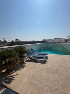 a blue lounge chair sitting on top of a swimming pool at Apartamentos RG Suites Jardines de Murillo in Seville