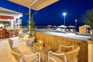 a patio with chairs and tables at night at Aeloria Boutique Hotel Corfu in Benitses