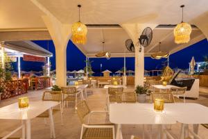 a restaurant with white tables and chairs and lights at Aeloria Boutique Hotel Corfu in Benitses