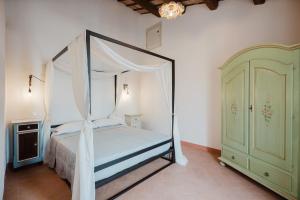 a bedroom with a canopy bed and a green cabinet at B&B Lallabiló in San Clemente