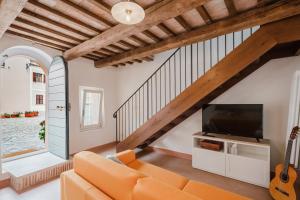 a living room with an orange couch and a tv at B&B Lallabiló in San Clemente
