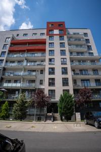 a large apartment building with a car parked in front of it at Barrique 30 - Breakfast Delivered & Minibar - Free parking - Mall Area in Braşov