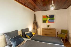 a bedroom with a bed and a chair at Chambres d'hôtes le Clou in Thiézac +3 photos