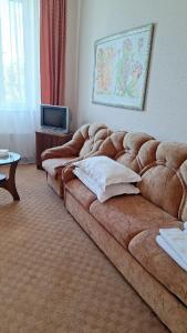 a living room with a large brown couch in a room at Барселона in Odesa