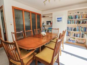 a dining room with a wooden table and chairs at Allt An Dorran in Acharacle
