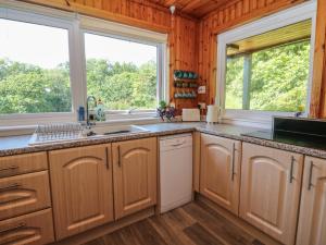 a kitchen with a sink and two windows at Allt An Dorran in Acharacle