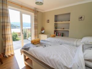 a bedroom with two beds and a large window at Allt An Dorran in Acharacle
